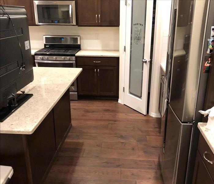 Kitchen flooring has been replaced with wood floors, and the kitchen has been fully cleaned and dried