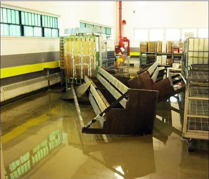 dirty floodwater moved about warehouse equipment and racks