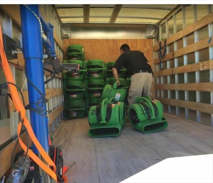 man loading SERVPRO equipment into a truck
