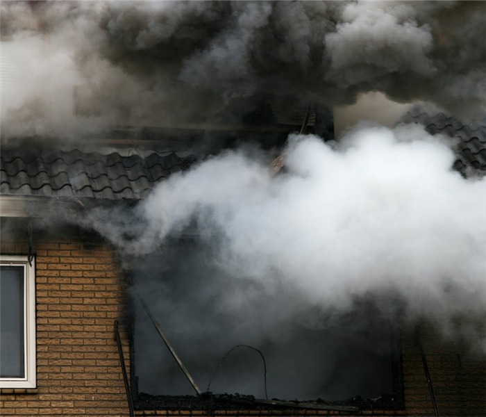 a house on fire with smoke billowing from the windows and doors