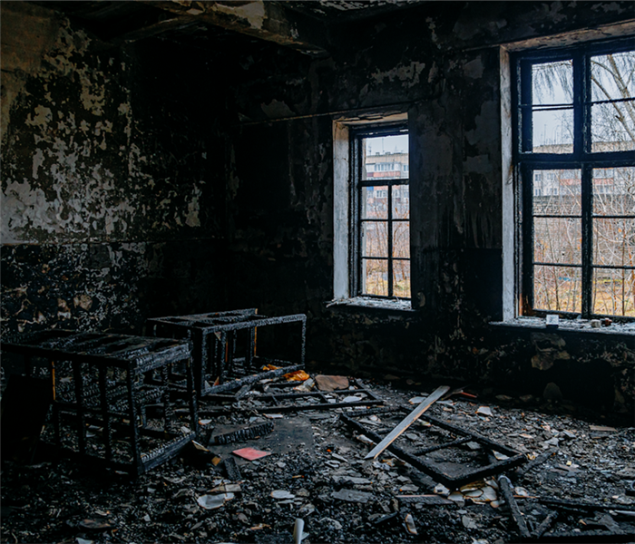 fire damaged room with debris and soot covering the floor