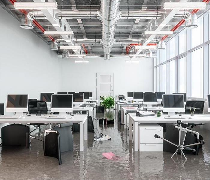 Office with lines of desks with water covering the floor