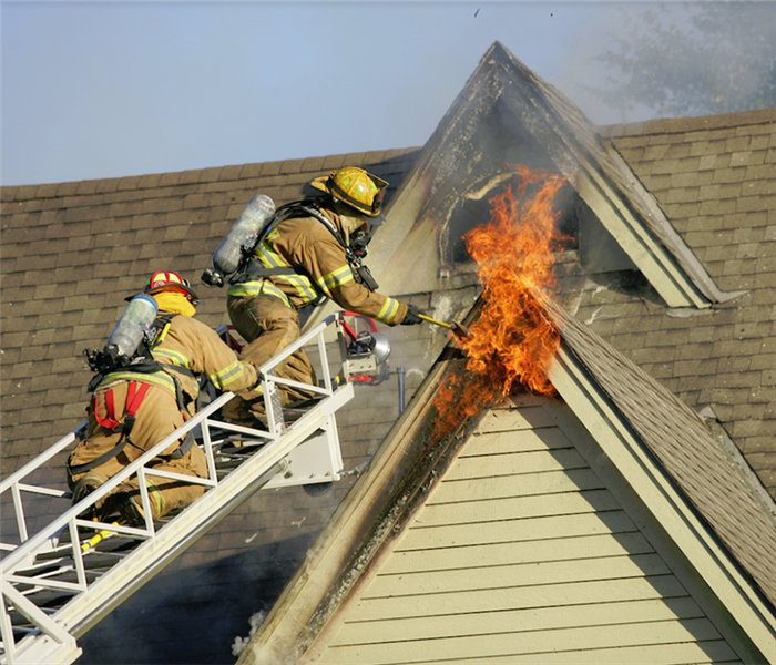 firefighters putting out a fire on a roof